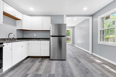 Kitchen with white cabinets, freestanding refriger
