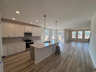 Kitchen featuring a large island, quartz countertops, pendant lighting, white 42