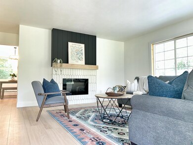 Living room featuring light wood-type flooring, pl