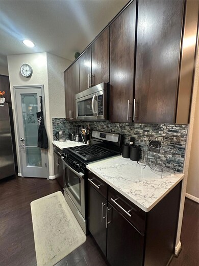Kitchen with range, tasteful backsplash, dark bro