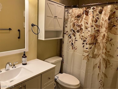 Full bath featuring toilet, vanity, and a shower w