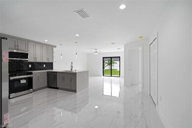 Kitchen featuring light marble finish floors, a peninsula, gray cabinetry, stainless steel appliances, and backsplash
