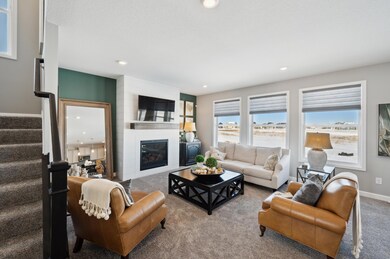 Feel at home in this spacious and open family room featuring a gas fireplace. (Photo of decorated model, actual home's finishes may vary slightly)