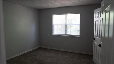 Unfurnished room with a textured ceiling and dark carpet