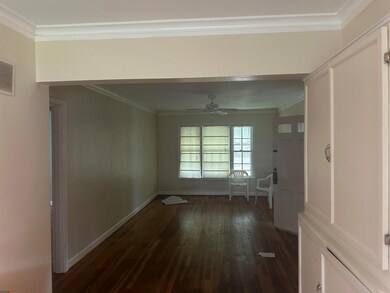 Hall with dark wood-type flooring and crown moldin