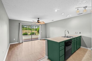 Kitchen with green cabinets, a sink, dishwasher, a ceiling fan, and baseboards