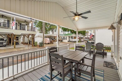 Wooden deck featuring a ceiling fan, outdoor dining area, and a residential view