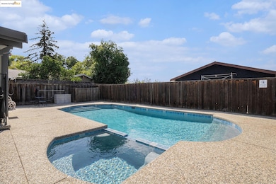 View of swimming pool featuring a pool with connected hot tub, a fenced backyard, and a patio area