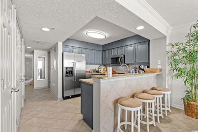 Kitchen featuring a textured ceiling, appliances w