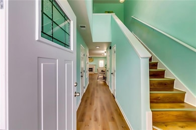 Stairway with visible vents, baseboards, and wood 