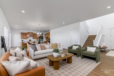 Living area with recessed lighting, a chandelier, stairway, and light wood-type flooring