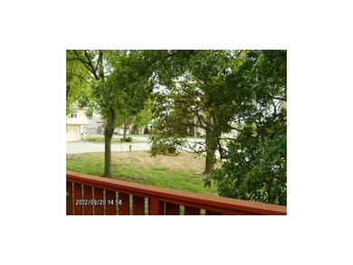 Corner unit with trees and grass.