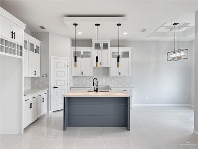 Kitchen with white cabinetry, sink, tasteful backsplash, and pendant lighting