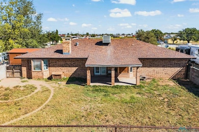 View of front of house featuring a fenced backyard, a patio, a shingled roof, and a chimney