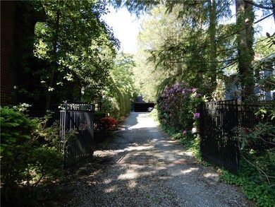 This handsomely gated driveway leads to the two ca