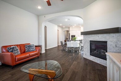 Living room featuring ceiling fan, a fireplace, an