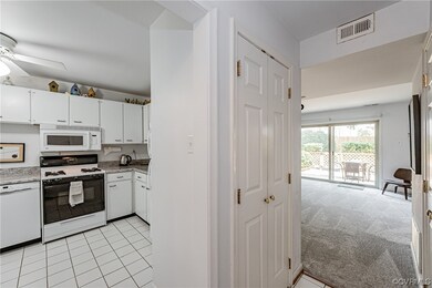 Kitchen featuring ceiling fan, white cabinetry, li
