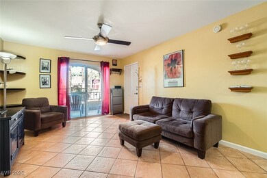 Living room with ceiling fan and light tile patter