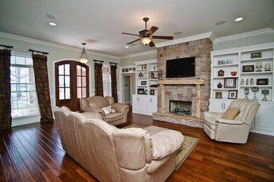 Family room complete with Stone fireplace, gas logs, recessed can lighting, arched openings and handscraped Teak hardwood floors. 