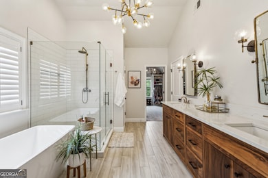 The Primary Suite is oversized and peaceful with Tray Ceilings, room for a sitting area or desk, and a spa-like En Suite Bathroom with a beautiful Walnut Double Vanity, Soaking Tub, and Glass Shower.