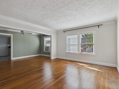 Living & Dining Areas with Crown Molding & Original Hardwood Floors