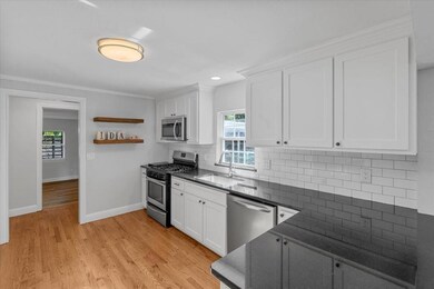 Kitchen with crown molding, light hardwood / wood-
