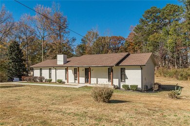 Single story home with brick siding, a porch, a front lawn, and a shingled roof
