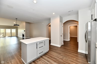 Kitchen with arched walkways, recessed light fixtures, and a center island.