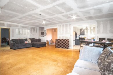 Living area featuring finished concrete flooring and a chandelier