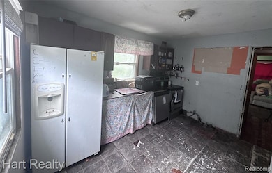 Kitchen featuring white fridge with ice dispenser and stainless steel range oven
