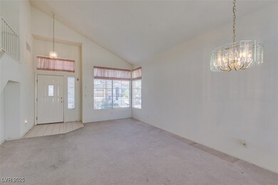 Foyer featuring high vaulted ceiling, carpet, and