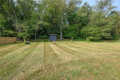 View of yard featuring a storage shed and view of wooded area