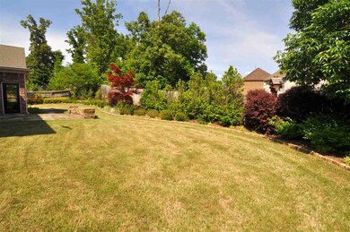 The fenced backyard is surrounded by beautiful lan