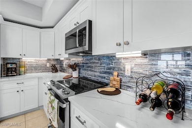 Kitchen featuring tasteful backsplash, light stone
