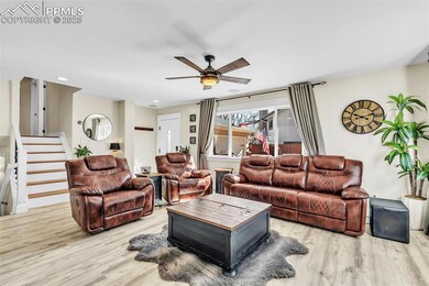 Living area featuring a ceiling fan, light wood-st