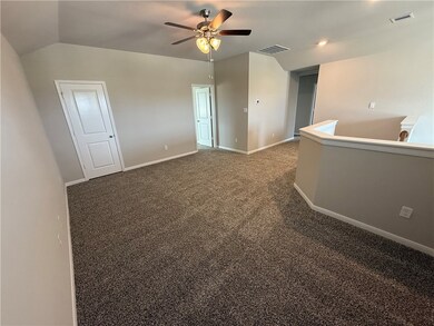Carpeted empty room featuring vaulted ceiling and