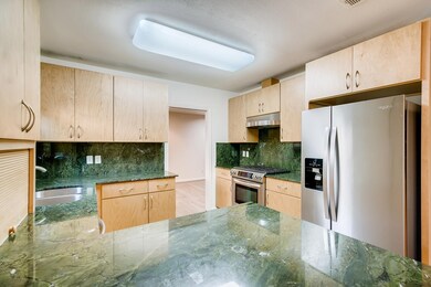 Updated kitchen has stainless steel appliances including a refrigerator