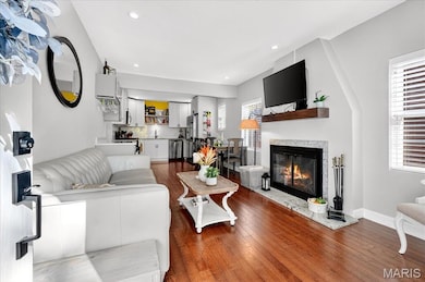Living area featuring wood finished floors, recessed lighting, and a premium fireplace