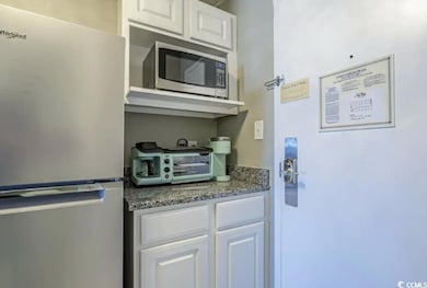 Kitchen featuring a toaster, stone counters, white