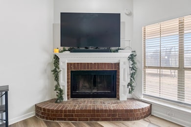 Room details with a fireplace, baseboards, and woo