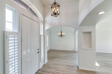 Foyer entrance with an inviting chandelier and light hardwood / wood-style floors
