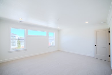 Empty room featuring light colored carpet, recessed lighting, and crown molding