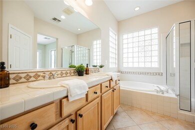 Full bath with a shower stall, double vanity, a ba