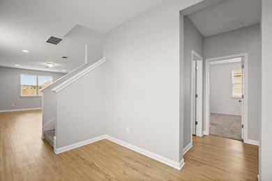 Hall featuring light wood finished floors, stairw