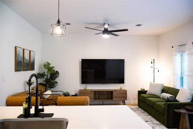 Living room featuring a ceiling fan and baseboards