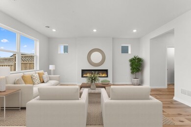 The living room features an electric fireplace and tons of natural light from the windows!