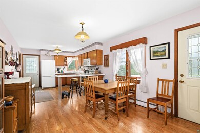Dining area with light wood-type flooring and a baseboard radiator