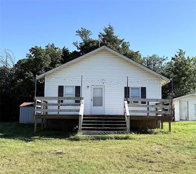 Rear view of property with a wooden deck and a lawn