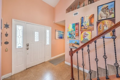 Entrance foyer with light tile patterned floors and stairs