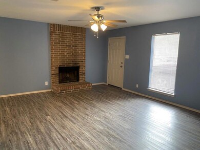 Unfurnished living room featuring ceiling fan, wo